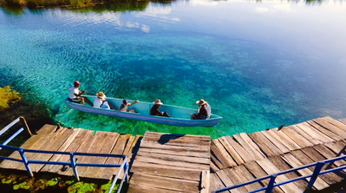 Boat crossing a turquoise lagoon near the site